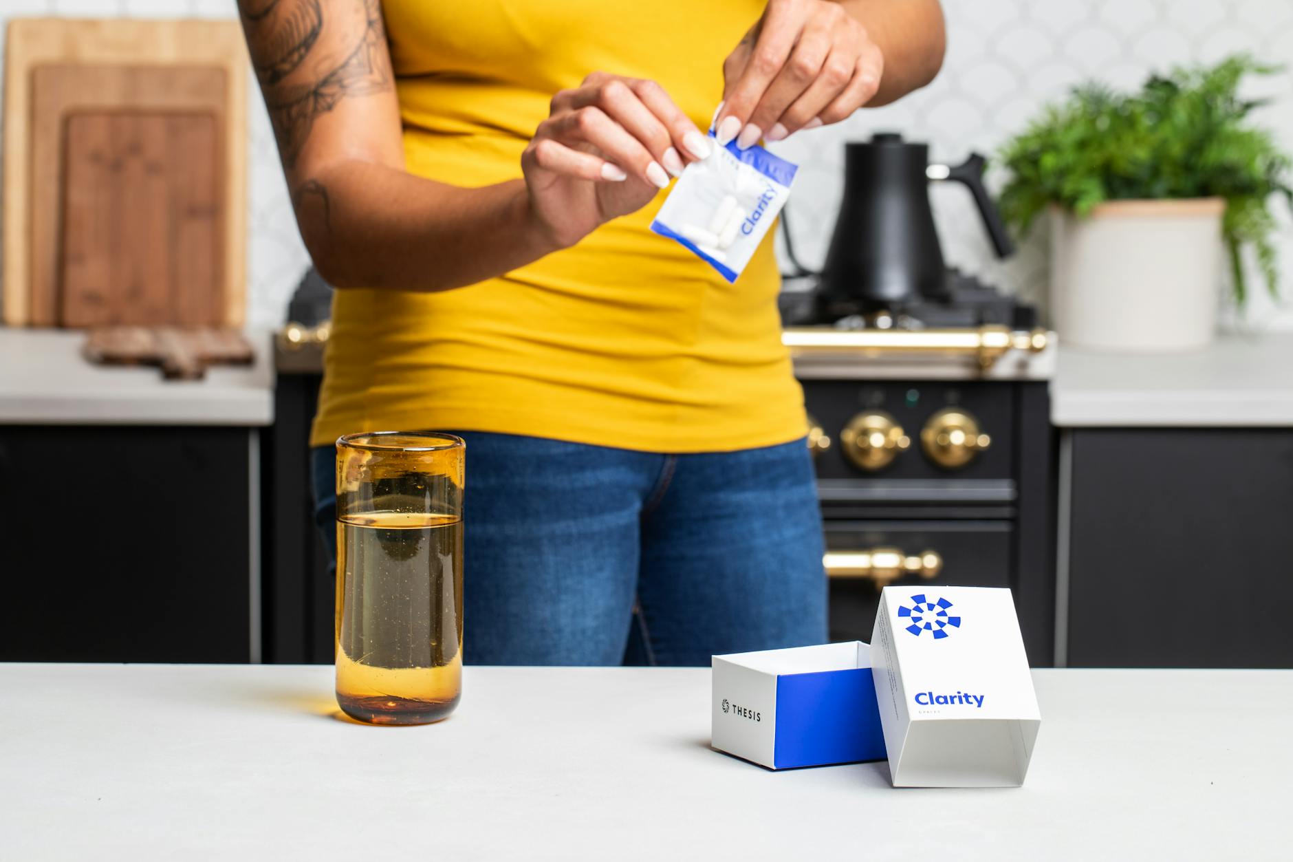 Close-up of person opening supplement sachet in modern kitchen setting. — Atrium Scientific Group