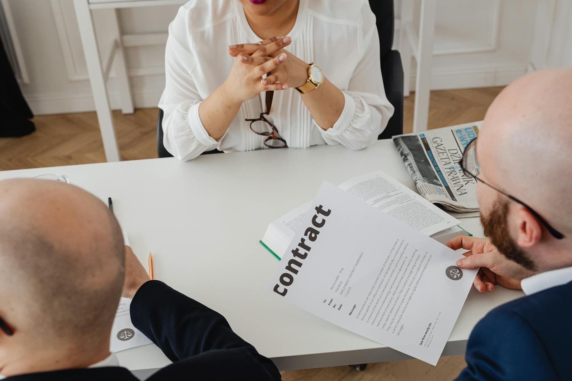 Business professionals discussing a contract in a modern office setting. — Atrium Scientific Group