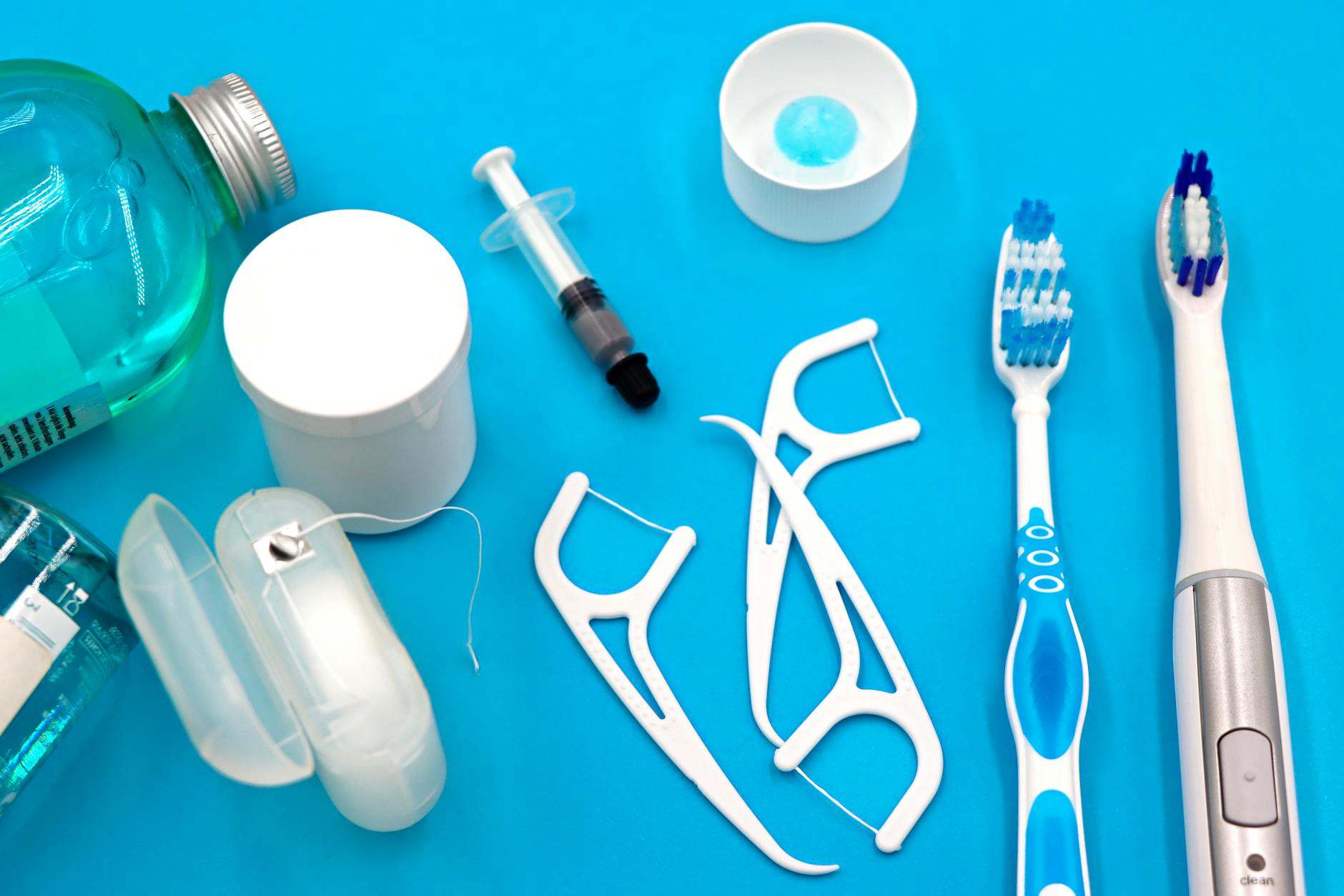 A variety of dental hygiene tools arranged neatly on a vibrant blue surface, showcasing oral care essentials. — Atrium Scientific Group