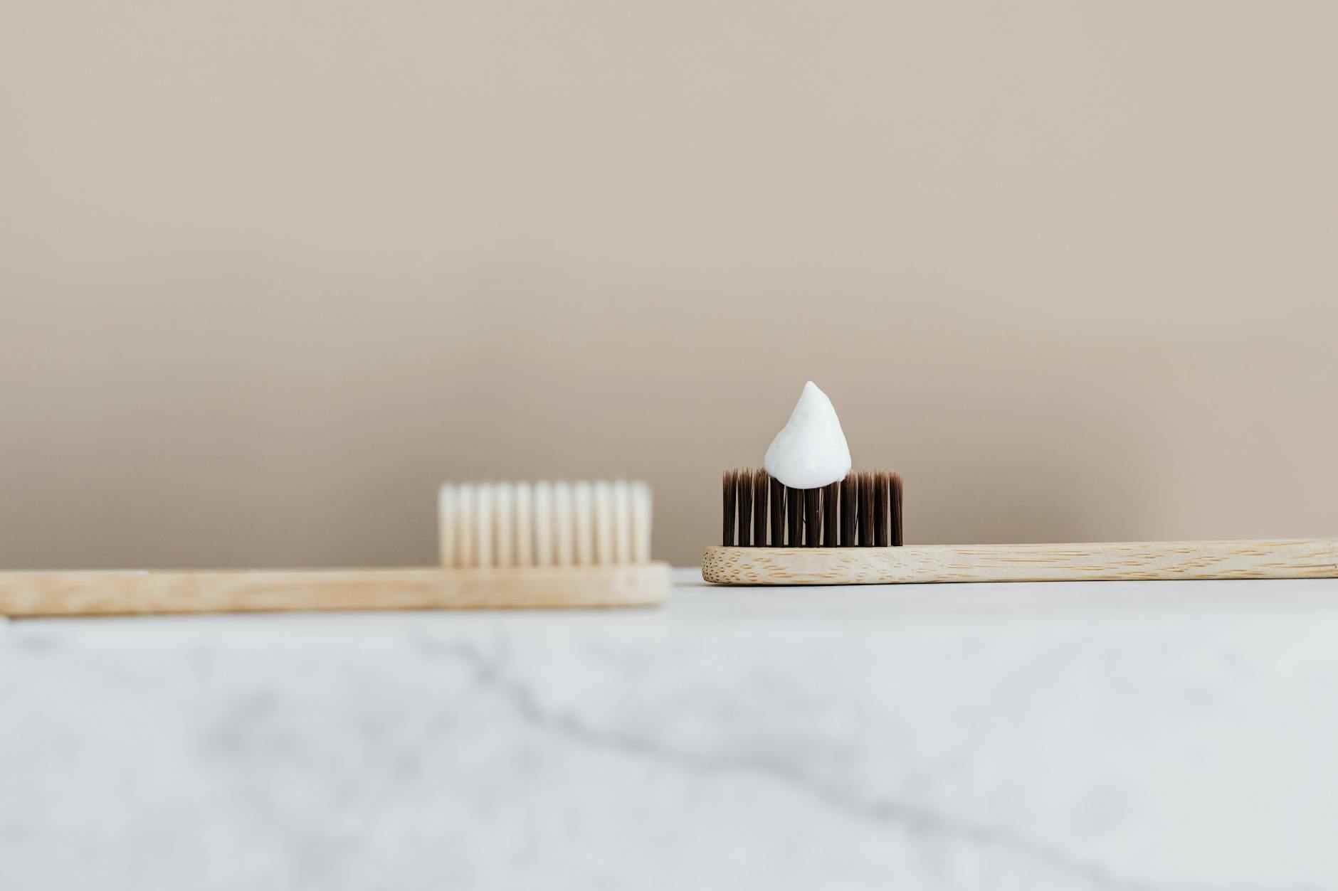 Close-up of a bamboo toothbrush with toothpaste in a minimalist setting. — Atrium Scientific Group