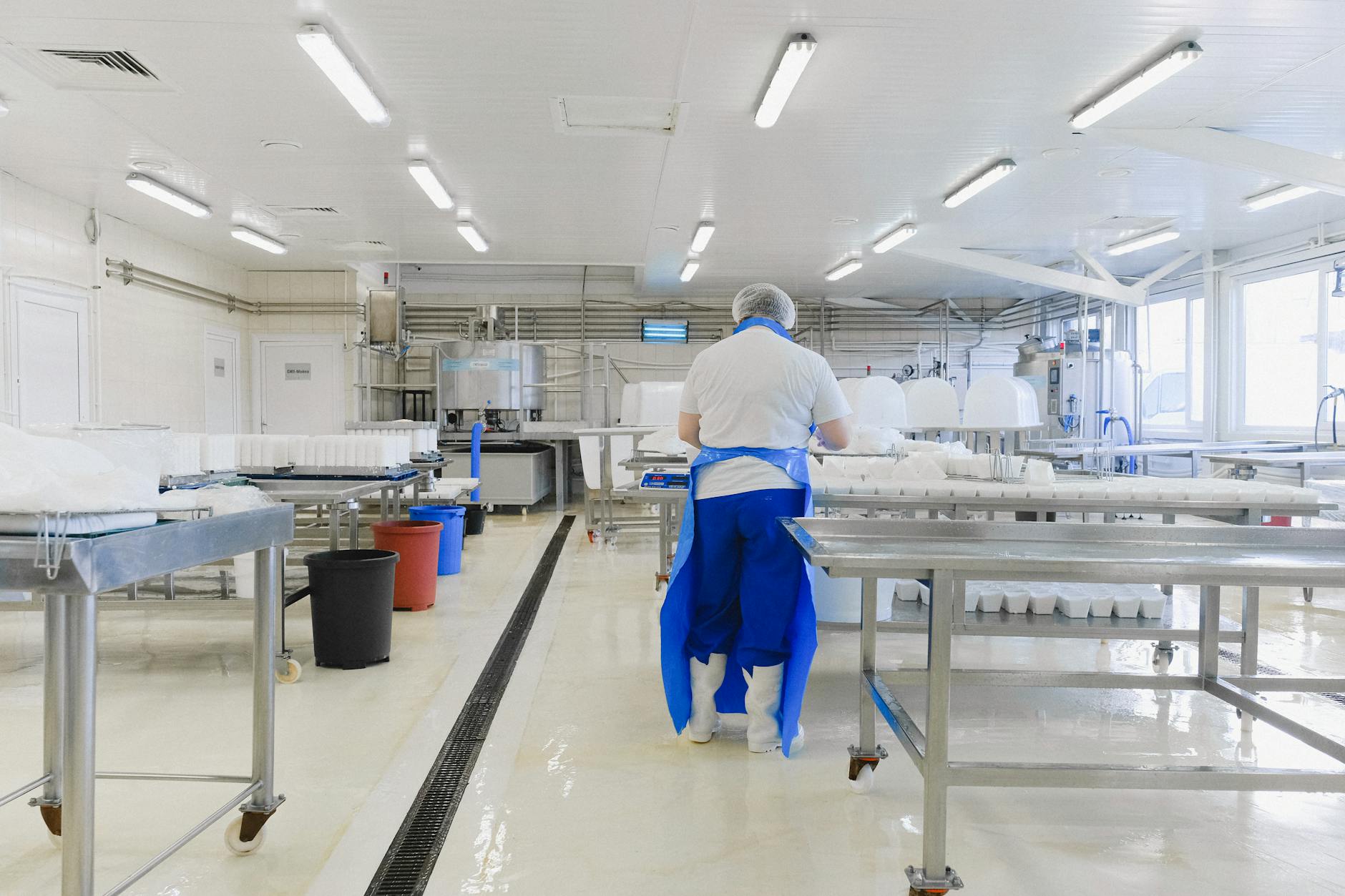 A person wearing protective clothing working in a bright, sterile laboratory environment. — Atrium Scientific Group
