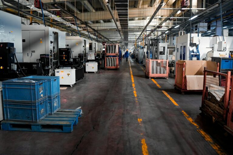 Vast industrial factory floor with machinery, crates, and structured workstations. — Atrium Scientific Group