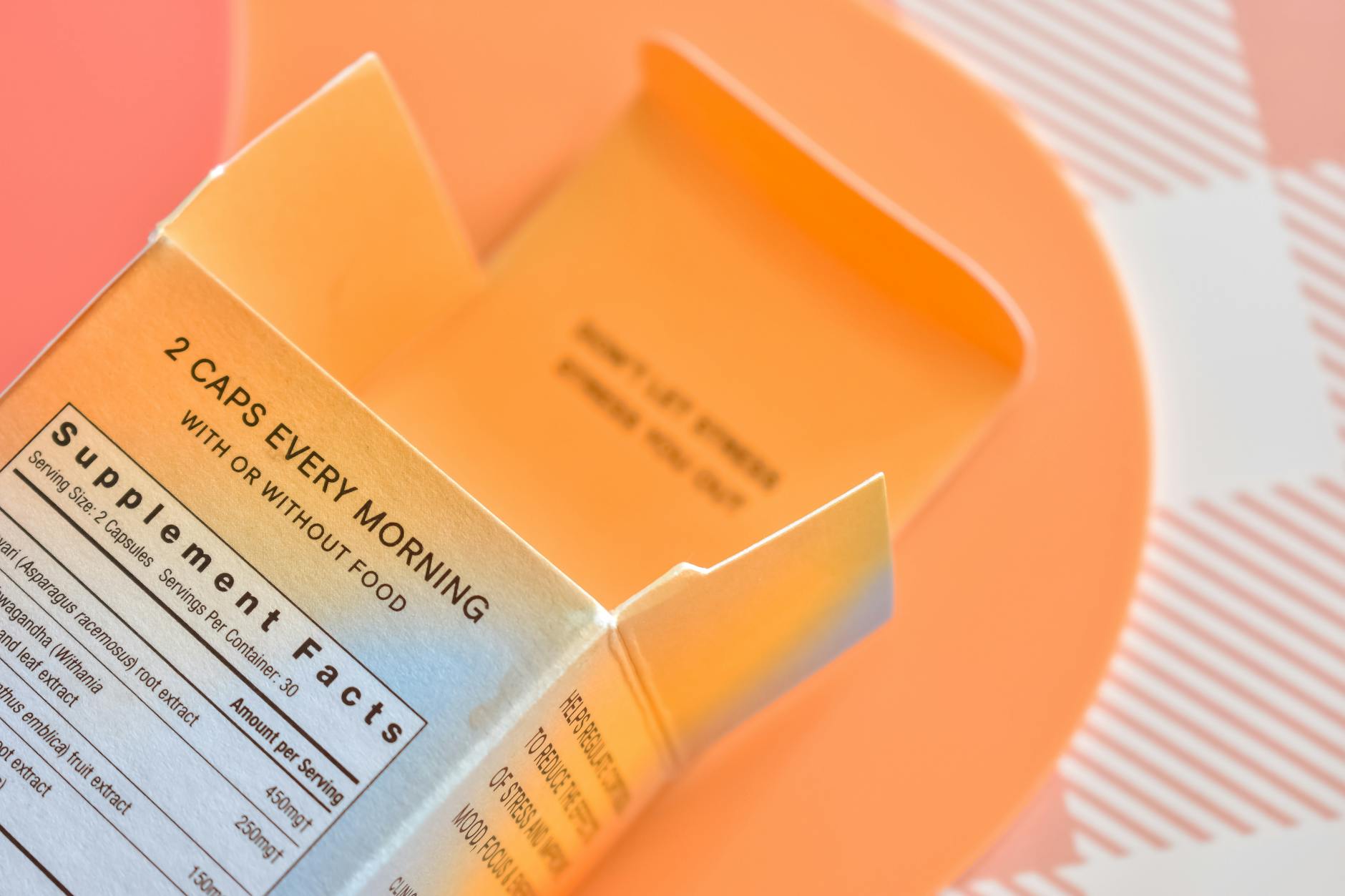 High angle view of an open supplement box on a peach-themed surface — Atrium Scientific Group